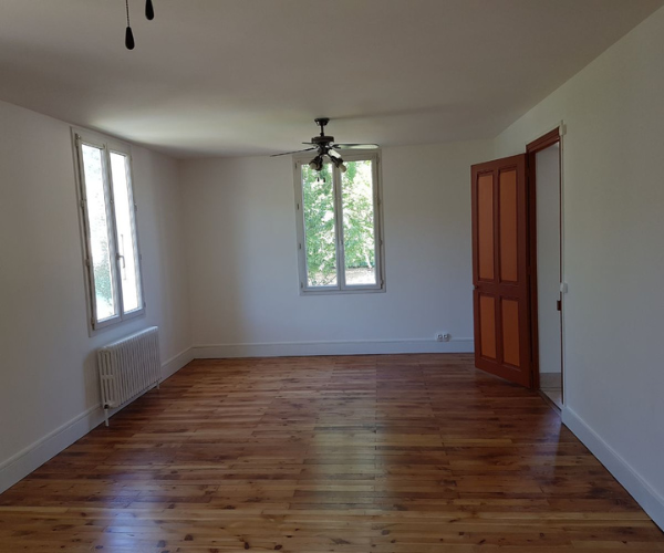 Salon rénové à Grenoble avec parquet vitrifié et murs blancs